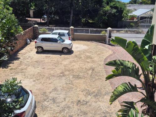 two cars parked in a dirt lot in a driveway at Afton Safari Lodge in Cape Town