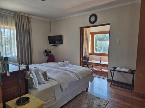 a bedroom with a bed and a clock on the wall at Afton Safari Lodge in Cape Town