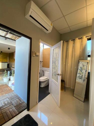 ein Badezimmer mit Toilette und weißer Tür in der Unterkunft 89 Bed & Studio Hostel in Godown