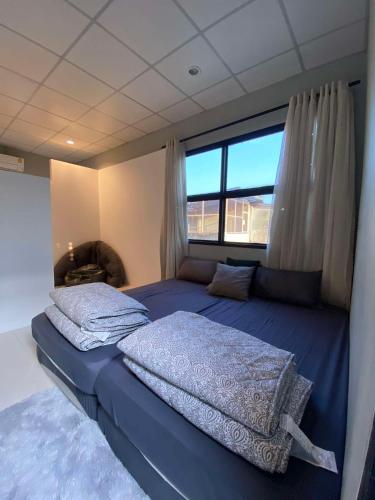 ein Schlafzimmer mit einem großen Bett und einem Fenster in der Unterkunft 89 Bed & Studio Hostel in Godown