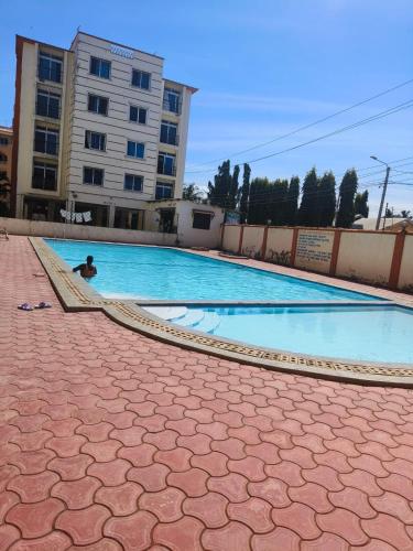 a large swimming pool with a person in the water at Mtwapa luxury apartment in Mombasa
