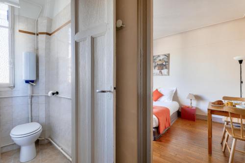 une salle de bain avec un lit et des toilettes dans une chambre dans l'établissement Quiet & Bright Studio-Prime Loc-Pantheon Paris 05, à Paris