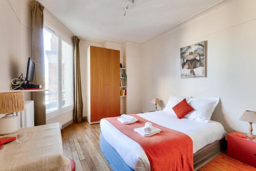 une chambre avec un grand lit avec une couverture rouge dans l'établissement Quiet & Bright Studio-Prime Loc-Pantheon Paris 05, à Paris