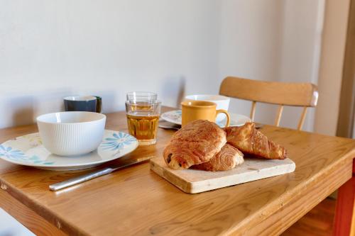 - une table avec des croissants, du café et une assiette de pain dans l'établissement Quiet & Bright Studio-Prime Loc-Pantheon Paris 05, à Paris