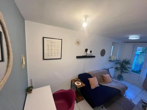 a living room with a couch and a table at Le petit refuge 28m2 2 personnes avec extérieur in Denain