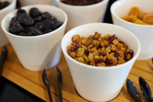a group of white cups filled with nuts and dried fruits at Hôtel restaurant Kyriad Fréjus in Fréjus