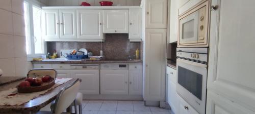 une cuisine avec une table avec un bol de fruits dessus dans l'établissement T4 en face Parc Longchamps min 28 night, à Marseille