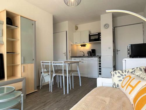 un salon avec une cuisine et une table et des chaises dans l'établissement Appartement 2 pièces - Gruissan GN450-A205, à Gruissan