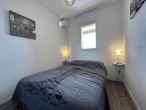 - une chambre avec un lit et une fenêtre avec deux lumières dans l'établissement Appartement 2 pièces - Gruissan GN450-A205, à Gruissan