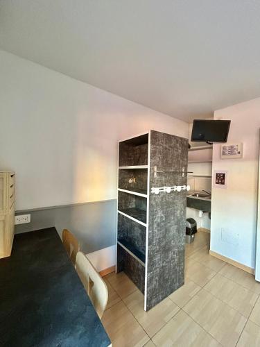 a dining room with a table and a cabinet at Hôtel Acajou in Argelès-sur-Mer