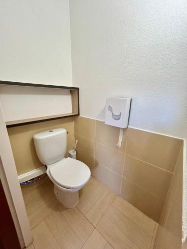 a bathroom with a white toilet in a room at Hôtel Acajou in Argelès-sur-Mer
