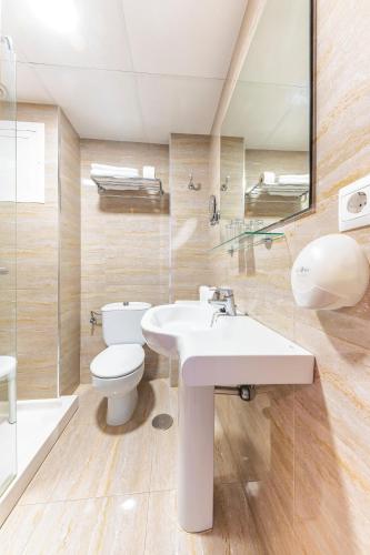 a bathroom with a white sink and a toilet at Port Fiesta Park in Benidorm