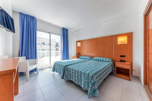 a bedroom with a bed and a table and a desk at Port Fiesta Park in Benidorm