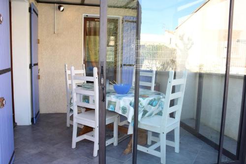 d'une table et de chaises sur un balcon avec une porte en verre. dans l'établissement Maison 3 pièces mezzanine - Gruissan GN520-048, à Gruissan