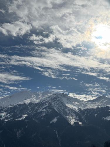 a view of a snow covered mountain under a cloudy sky at Cafekush tosh in Tosh