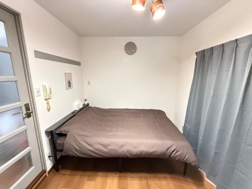 a bedroom with a bed in a room with a window at Discover Fukuoka House in Fukuoka