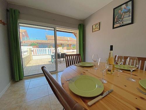 - une table à manger avec des assiettes et des verres à vin dans l'établissement Maison 3 pièces - Gruissan GA080-086, à Gruissan