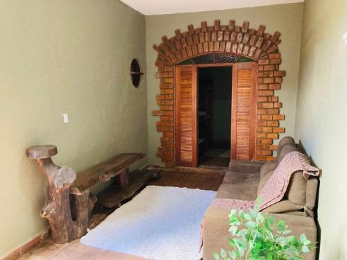 a living room with a couch and a brick wall at LINDA CASA A 500mts da PRAIA DE CIBRATEL PARA CURTIR COM AMIGOS E FAMILIA in Itanhaém