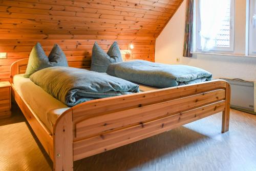 2 camas en una habitación con pared de madera en Separates Ferienhaus Speicherhäusle auf dem Hasenhof mit eigener Terrasse mit Grill, Kachelofen, WLAN, en Hornberg