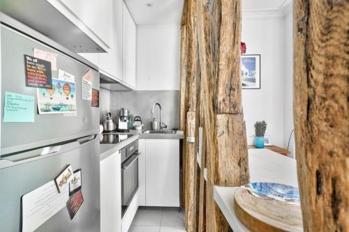 La cuisine est équipée d'un réfrigérateur et d'un évier. dans l'établissement Spacieux appart vue Montmartre, à Paris
