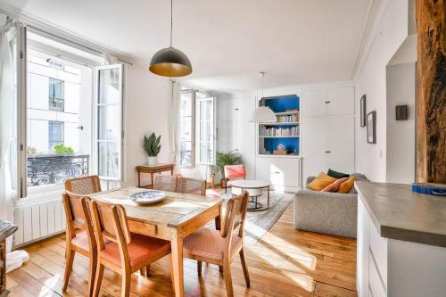 une cuisine et un salon avec une table et des chaises dans l'établissement Spacieux appart vue Montmartre, à Paris
