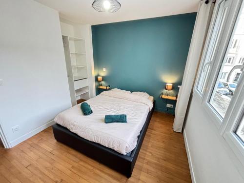 une chambre avec un lit et un mur bleu dans l'établissement La Madeleine avec parking, à Angers