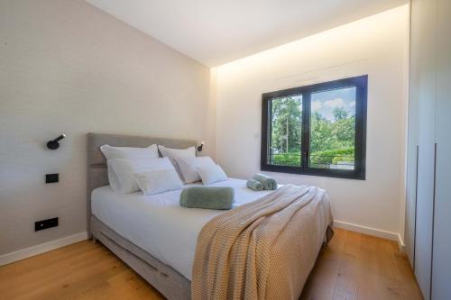 Un dormitorio con una cama grande con ventana. en Villa Bleu Rivage - Villa les pieds dans l'eau, en Veyrier-du-Lac