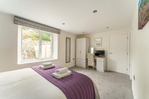 a bedroom with a large bed with two pillows on it at Lakes Cottage in Backbarrow