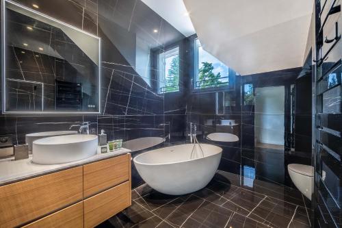 baño con 3 lavabos y bañera grande en Villa Bleu Rivage - Villa les pieds dans l'eau, en Veyrier-du-Lac