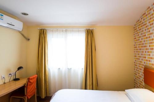 a bedroom with a bed and a desk and a window at Home Inn Shijiazhuang West 2nd Ring Road Huai'an Road in Shijiazhuang