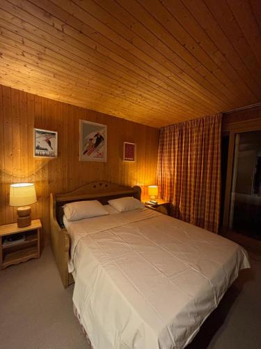 um quarto com uma cama grande com dois abajures sobre mesas em Appartement 4 personnes - Magnifique vue montagne em Méribel
