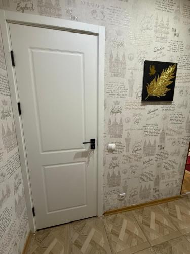 a white door in a room with a wall with writing at Apartament cu o camera Buiucani in Durleşti