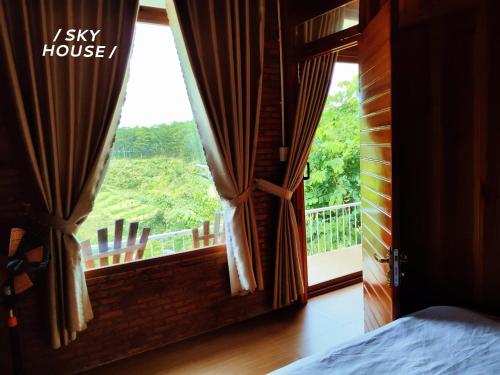 a bedroom with a window with a view of a balcony at Lưng Chừng House in Da Lat