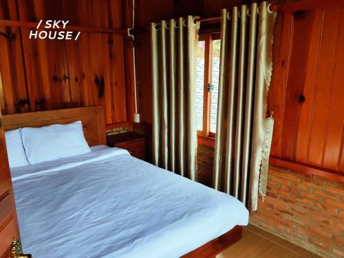 a bedroom with a bed and a window at Lưng Chừng House in Da Lat