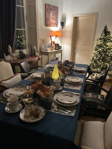 a long blue table with food and a christmas tree at Chez Nous Laval in Laval