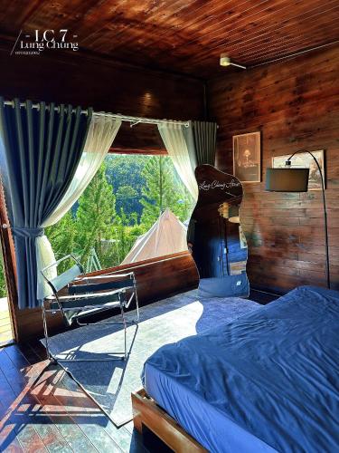 a bedroom with a bed and a large window at Lưng Chừng House in Da Lat