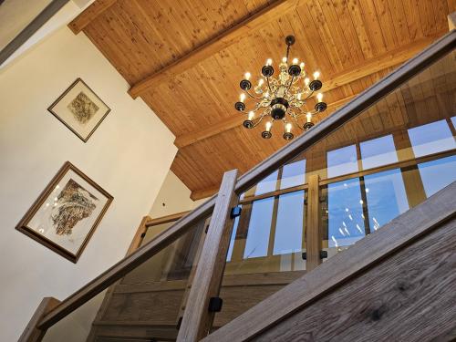 a chandelier hangs from the wooden ceiling of a staircase at Ferienhaus Weitblick, Apartment Ritzinger GmbH in Stixenlehen