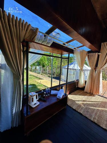 a room with curtains and a table with a microwave at Lưng Chừng House in Da Lat