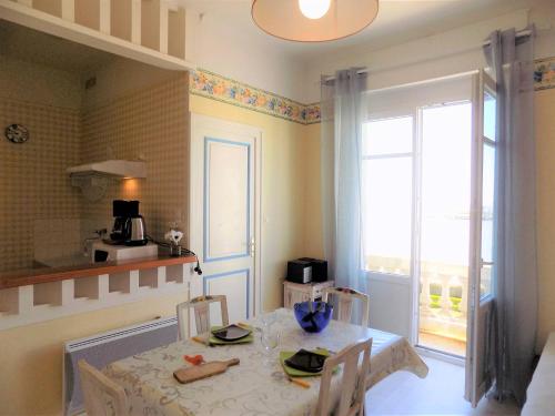 une cuisine avec une table et des chaises ainsi qu'une fenêtre dans l'établissement Royan PONTAILLAC - STUDIO PLEINE VUE MER - Ideal PETIT BUDGET, à Royan
