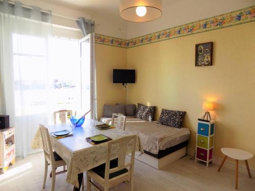 - une chambre avec un lit, une table, une table et des chaises dans l'établissement Royan PONTAILLAC - STUDIO PLEINE VUE MER - Ideal PETIT BUDGET, à Royan