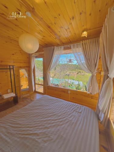 a bedroom with a large bed with a large window at Lưng Chừng House in Da Lat