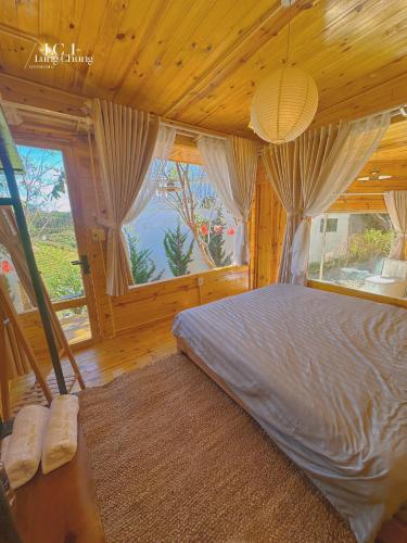 a bedroom with a bed and a large window at Lưng Chừng House in Da Lat