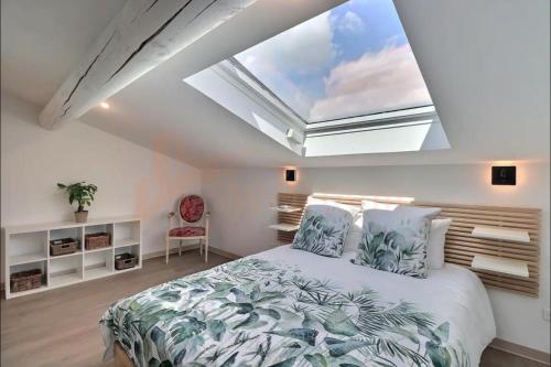 - une chambre avec un grand lit et une grande lucarne dans l'établissement l'Oasis de Grand'Ma, à Aix-en-Provence