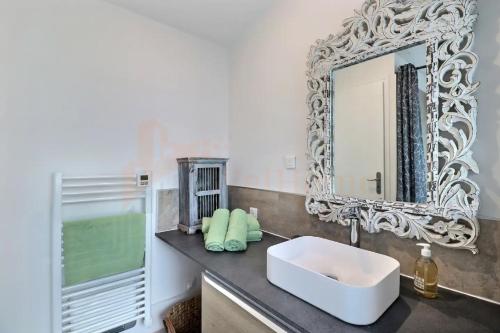 une salle de bain avec un lavabo blanc et un miroir dans l'établissement l'Oasis de Grand'Ma, à Aix-en-Provence