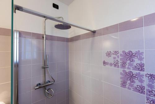 a bathroom with a shower with purple tiles at Spluga "Relax & Apartaments" by Alfio Colombo in Sorico