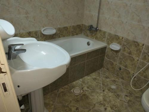 a bathroom with a sink and a bath tub at luxury private 2bhk appartment in Sharjah