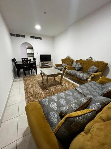 a living room with two couches and a table at luxury private 2bhk appartment in Sharjah