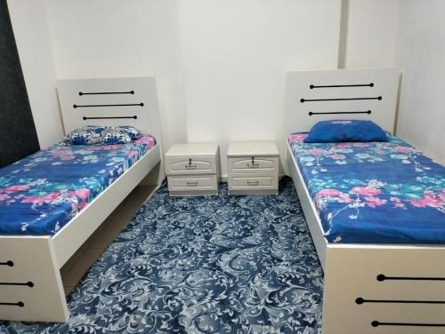 two beds sitting next to each other in a room at luxury private 2bhk appartment in Sharjah