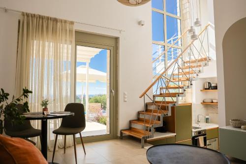 a living room with a staircase and a table and chairs at Nikiti Dream Villas in Nikiti