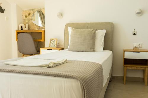 a bedroom with a bed with a gray headboard at Nikiti Dream Villas in Nikiti
